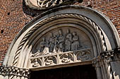 Castiglione Olona -  Chiesa della Collegiata. Lunetta del portale con la scultura di una 'Sacra Conversazione' 